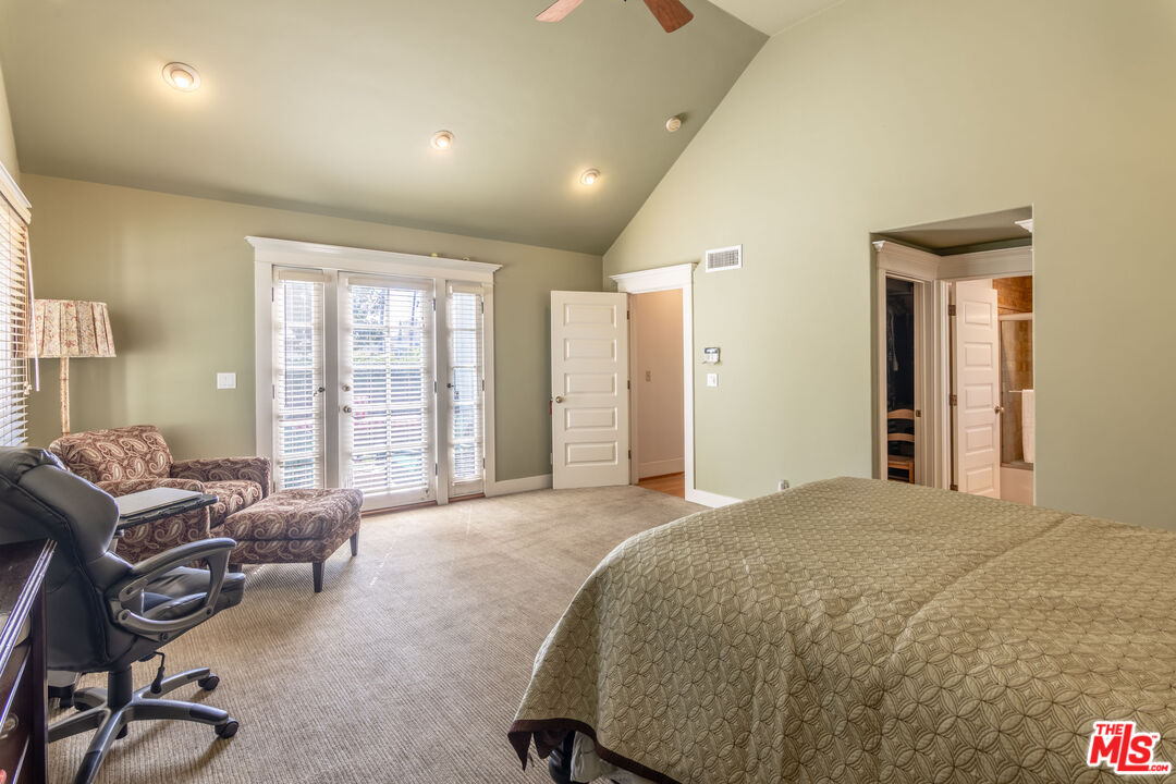 880 Wellesley Avenue Los Angeles, CA 90049 - Photo 17 of 29 a spacious bedroom with a bed a table and chair