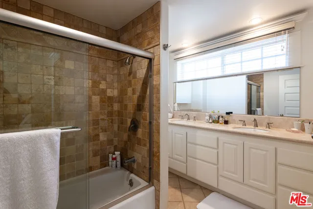 a bathroom with a double vanity sink toilet and shower