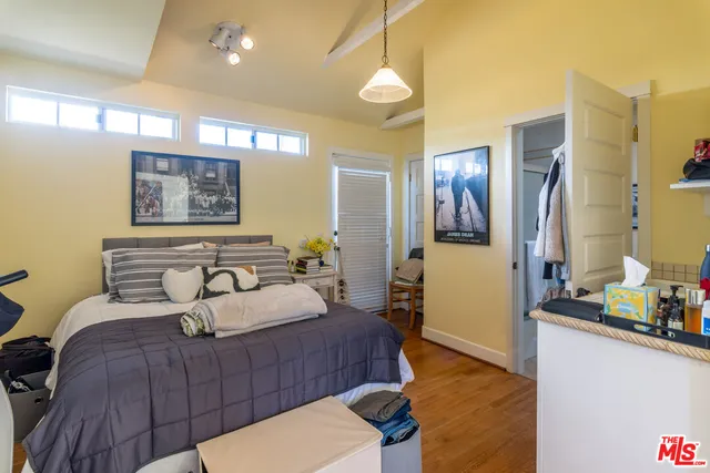 a bedroom with a bed and a dresser next to a window