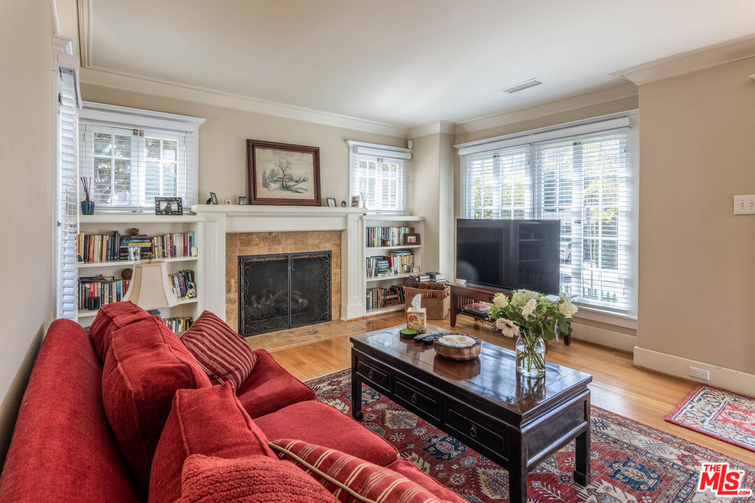 880 Wellesley Avenue Los Angeles, CA 90049 - Photo 5 of 29 a living room with furniture a flat screen tv and a fireplace