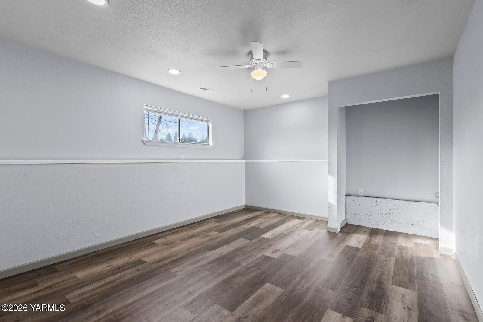 512 Taylor Road Selah, WA 98942 - Photo 27 of 36 an empty room with wooden floor and chandelier