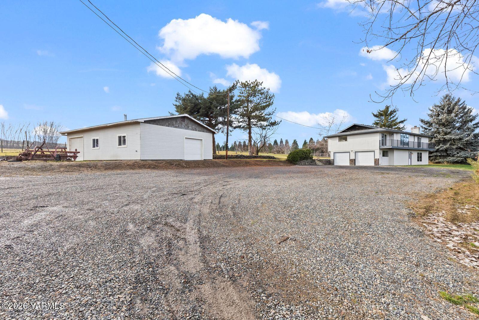 512 Taylor Road Selah, WA 98942 - Photo 33 of 36 a view of a white house with a big yard and large trees
