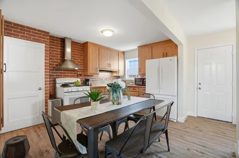 a kitchen with stainless steel appliances a dining table chairs and a refrigerator