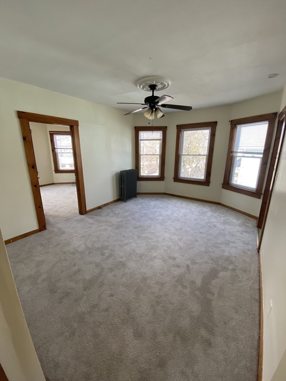 10 Lafayette Street, Unit 2 Attleboro, MA 02703 - Photo 2 of 9 an empty room with windows and fireplace