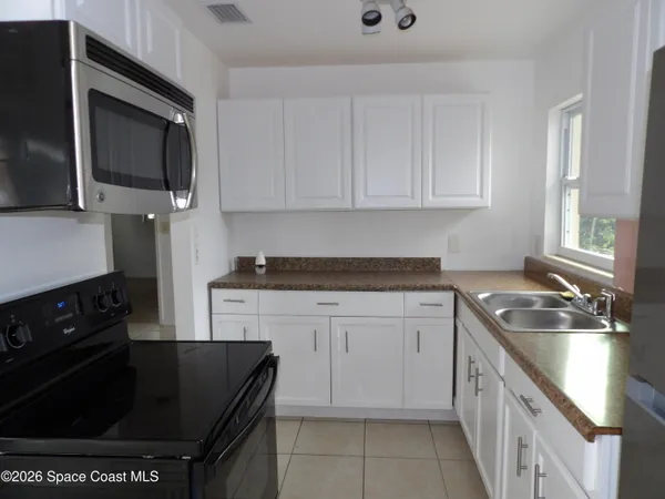a kitchen with stainless steel appliances granite countertop a sink stove and microwave