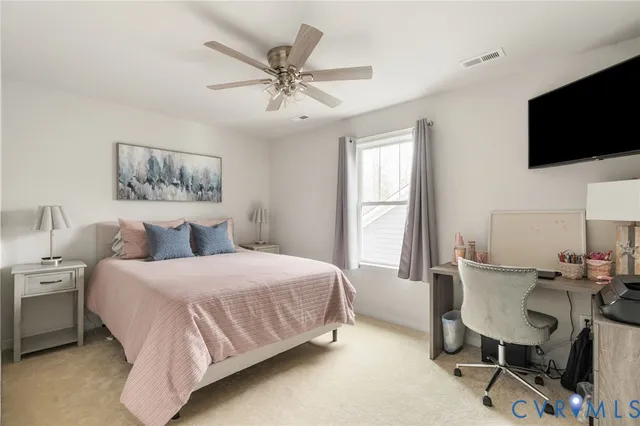 a bedroom with a beds window and a flat screen tv