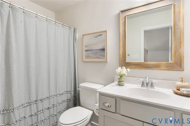 a bathroom with a sink a toilet and shower curtain