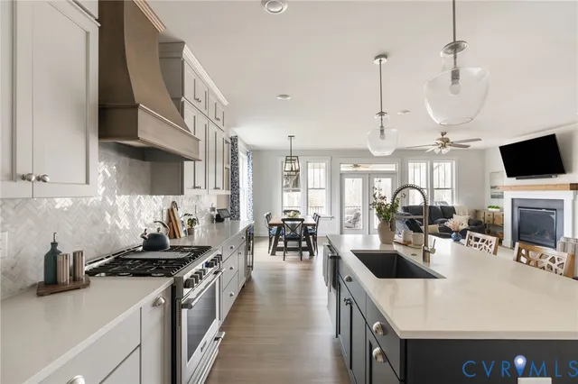 a kitchen with lots of counter top space stove sink and living room view