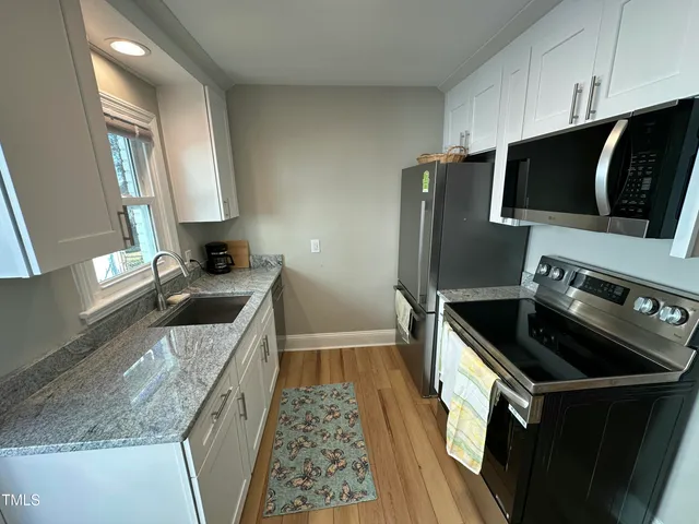 a kitchen with a sink stove and microwave
