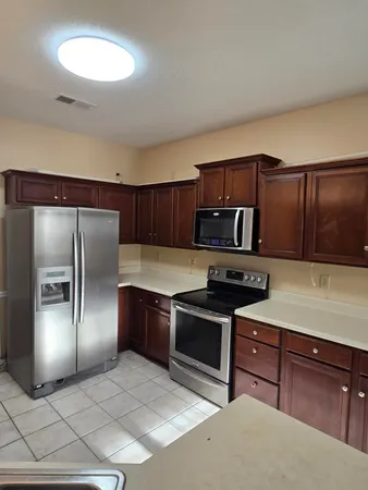 a kitchen with stainless steel appliances granite countertop a refrigerator and a stove