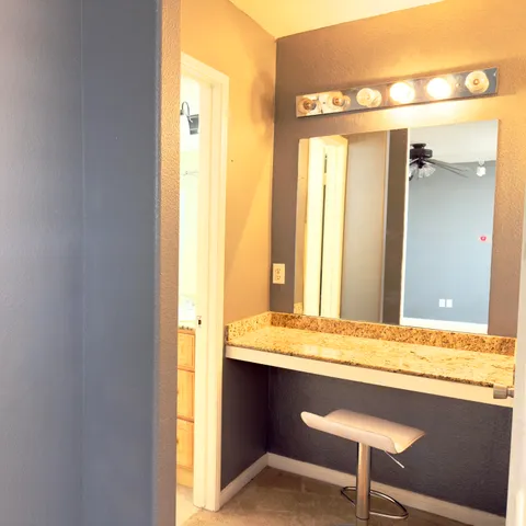 a bathroom with a granite countertop sink and a mirror