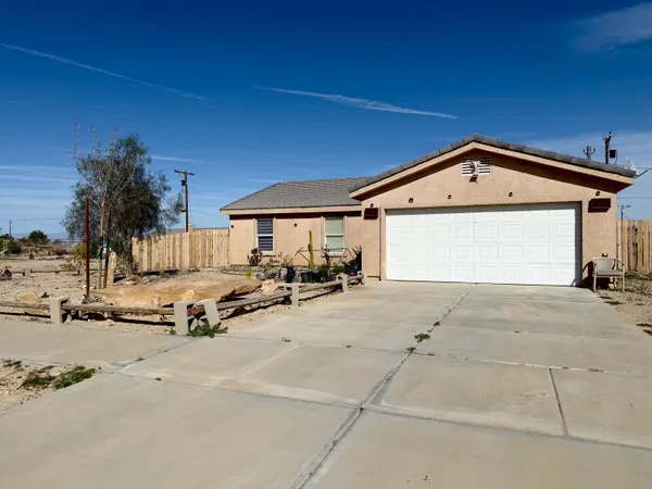 a view of the house with outdoor space and parking area