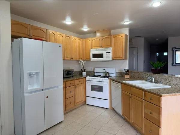 a kitchen with white cabinets and white appliances