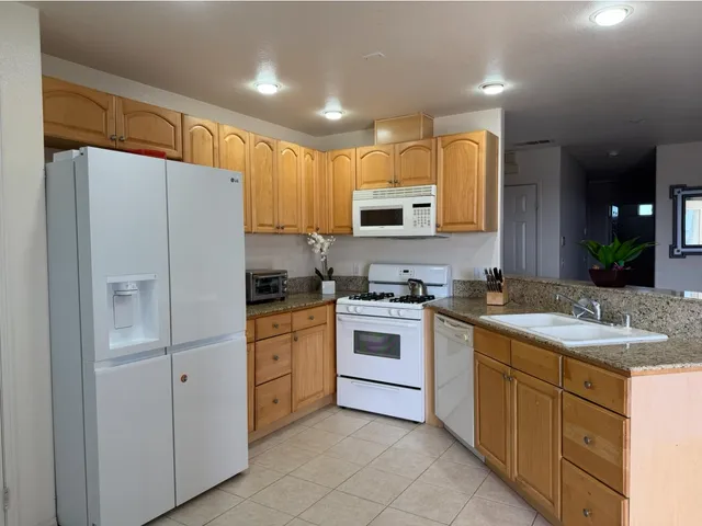 a kitchen with white cabinets and white appliances