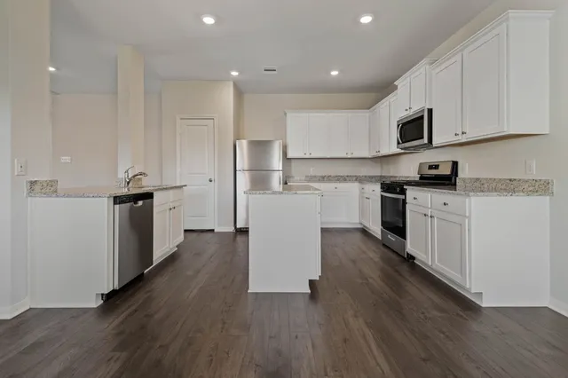 a kitchen with a sink a microwave and cabinets