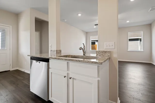 a bathroom with a granite countertop sink and a refrigerator