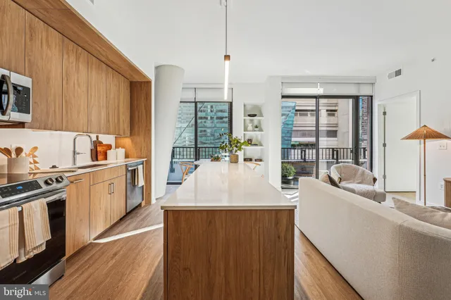 a kitchen with stainless steel appliances granite countertop a sink a stove and a wooden floors