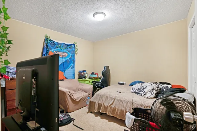 a bedroom with a bed and a computer on the desk