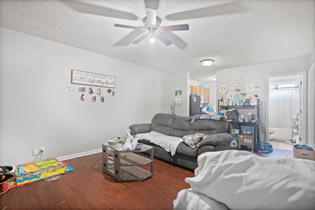 a living room with furniture and a wooden floor