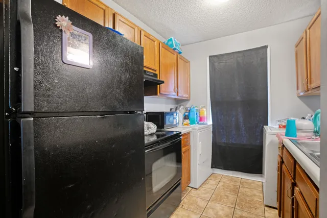 a kitchen with a sink a refrigerator and cabinets