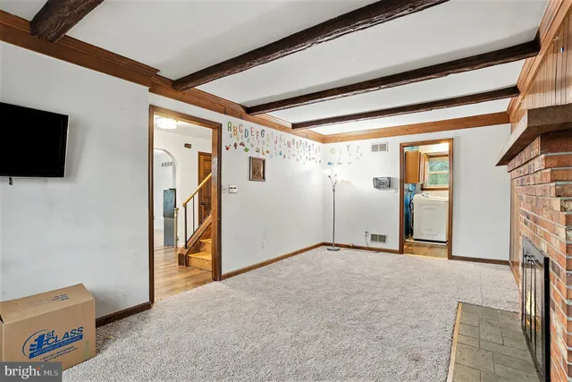 a view of an empty room with a fireplace and a window