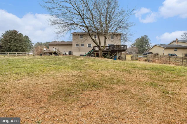 a front view of a house with a yard and mountain view in back