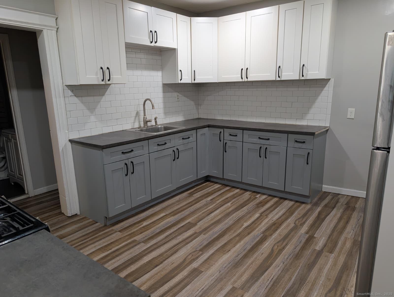 a kitchen with stainless steel appliances granite countertop a sink stove and cabinets