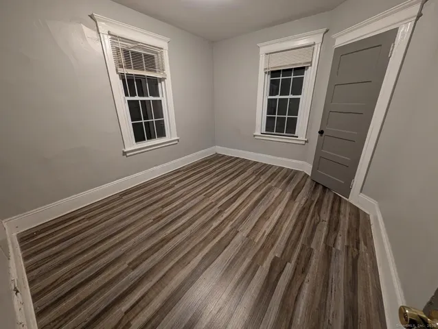 a view of a room with wooden floor and windows