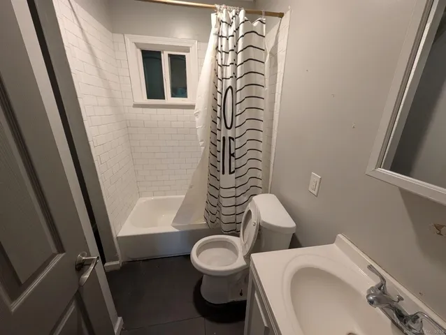 a white toilet sitting next to a bathroom sink and tub