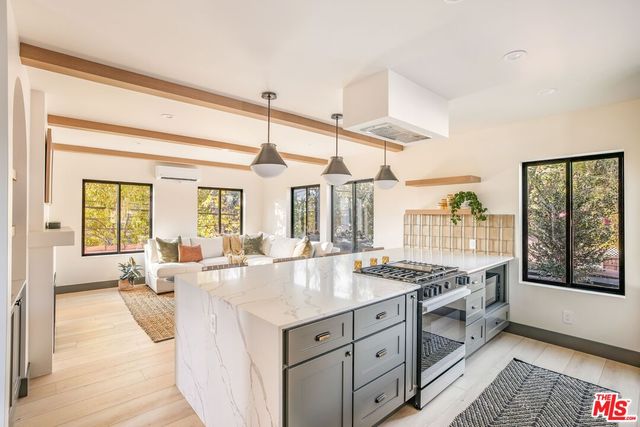 a living room with stainless steel appliances granite countertop a stove and cabinets