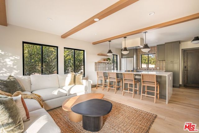 a living room with furniture a rug and a floor to ceiling window