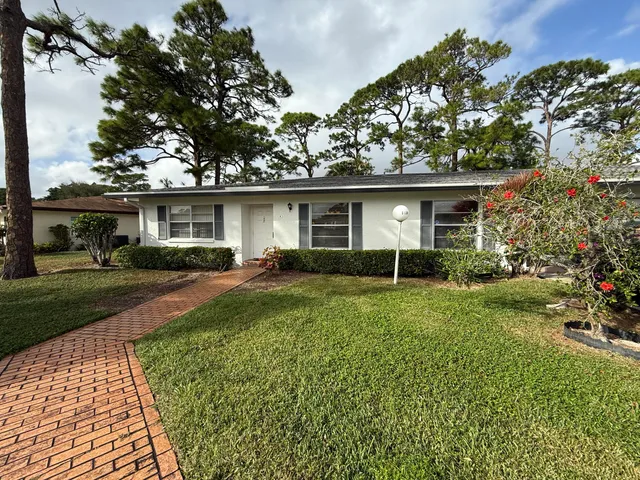 a front view of a house with a yard and trees