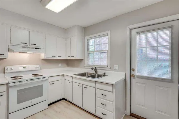 a kitchen with white cabinets and a sink