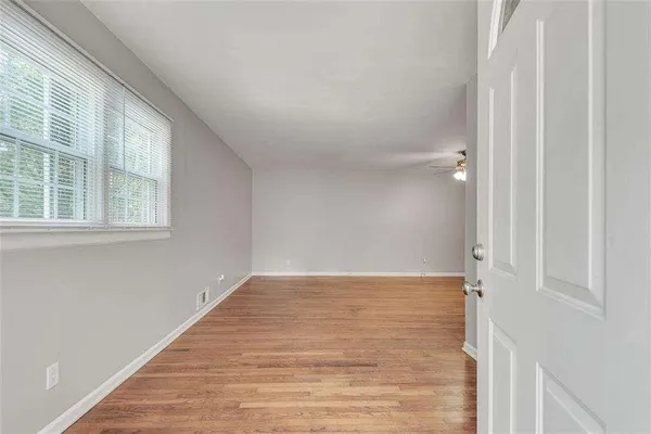 an empty room with wooden floor and windows