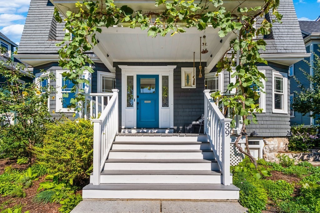 a view of a house with potted plants and a fountain