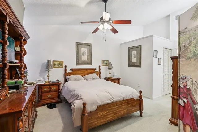 a bedroom with a bed a dresser and potted plants