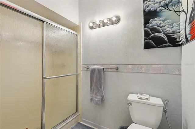 a bathroom with a toilet and a shower