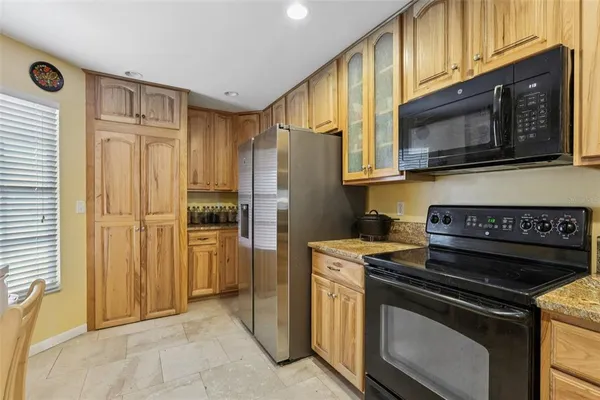 a kitchen with stainless steel appliances granite countertop a stove a microwave and a refrigerator