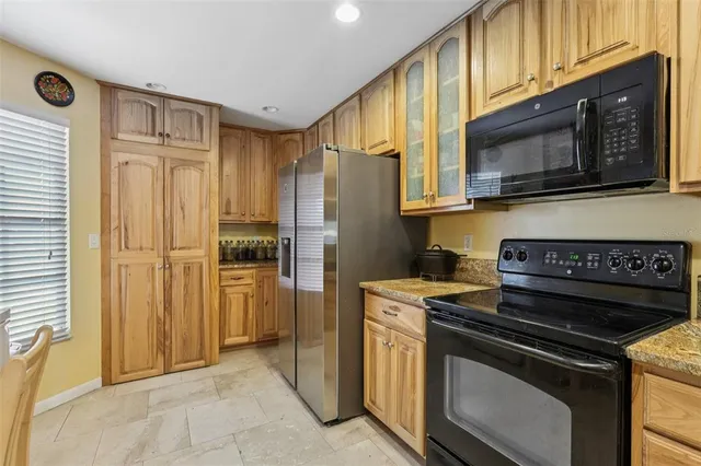 a kitchen with stainless steel appliances granite countertop a stove a microwave and a refrigerator