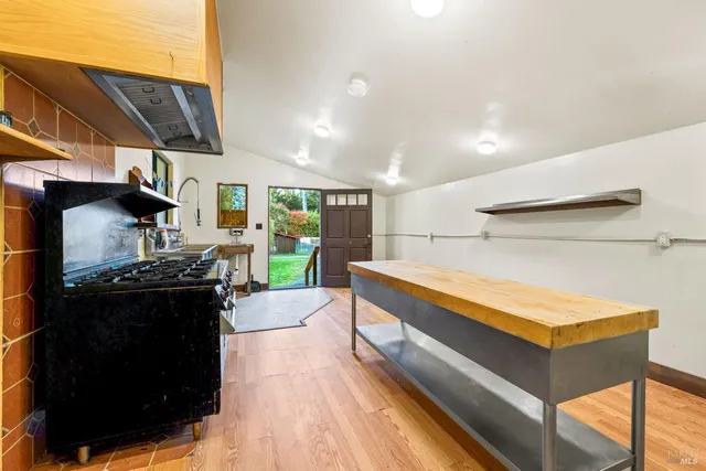a living room with furniture a flat screen tv and kitchen view