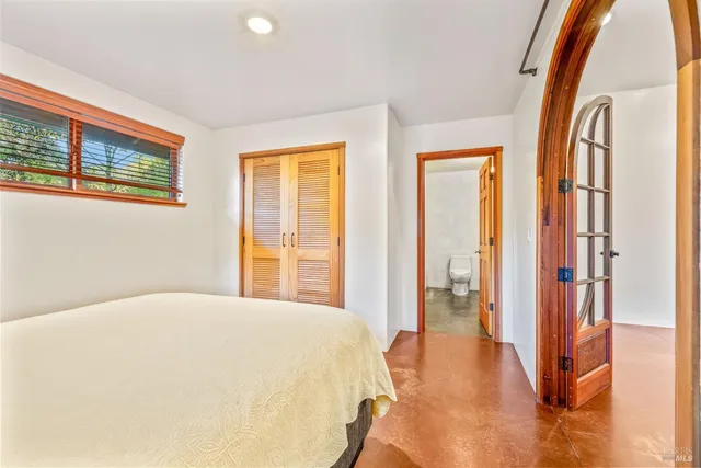 a spacious bedroom with a large bed and a large window