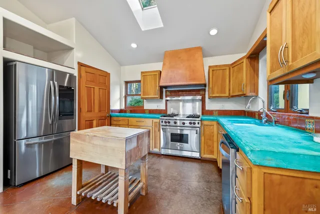 a kitchen with stainless steel appliances a stove a sink and a refrigerator