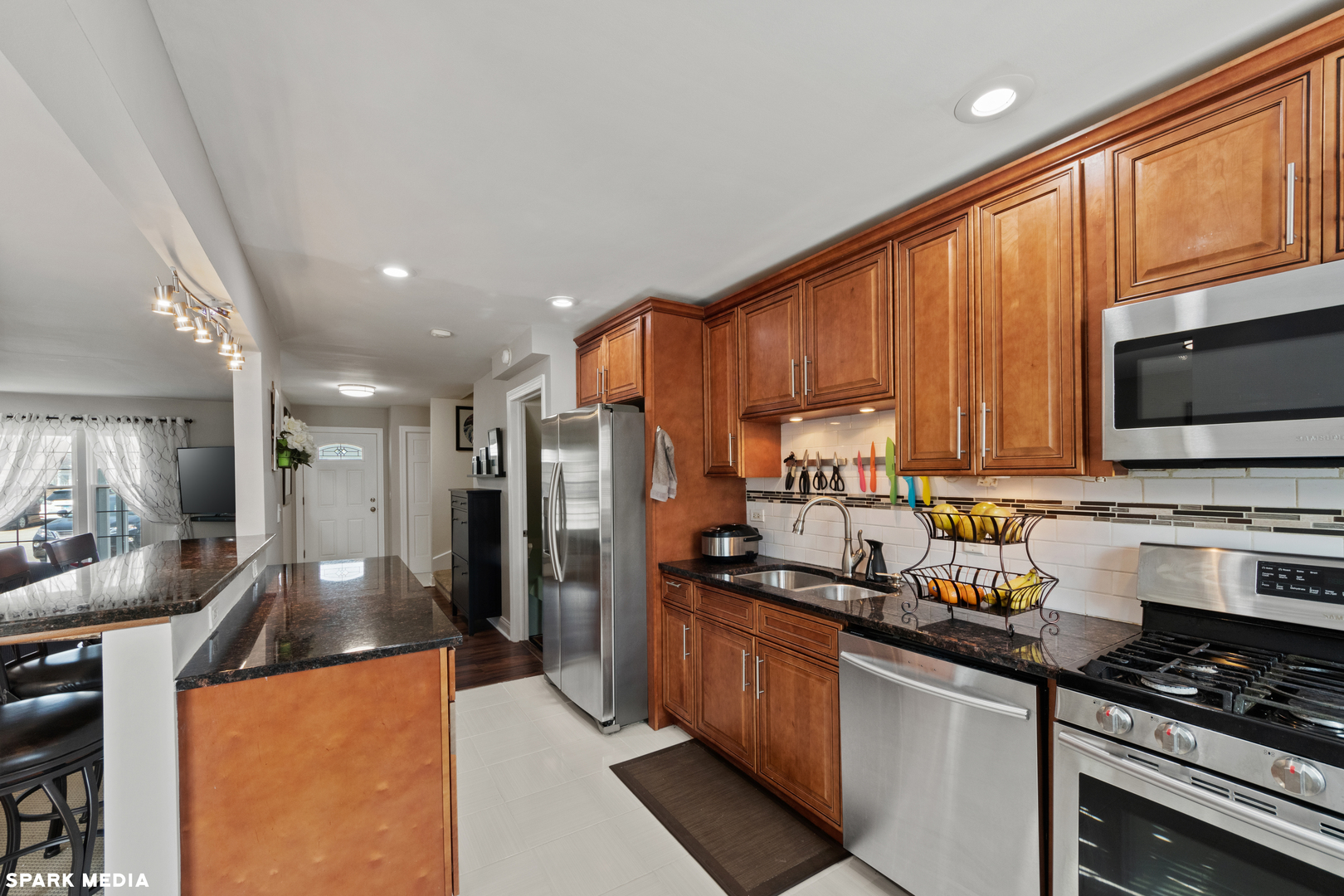 7612 Manchester Manor Hanover Park, IL 60133 - Photo 12 of 30 a kitchen with stainless steel appliances granite countertop a refrigerator stove microwave and sink