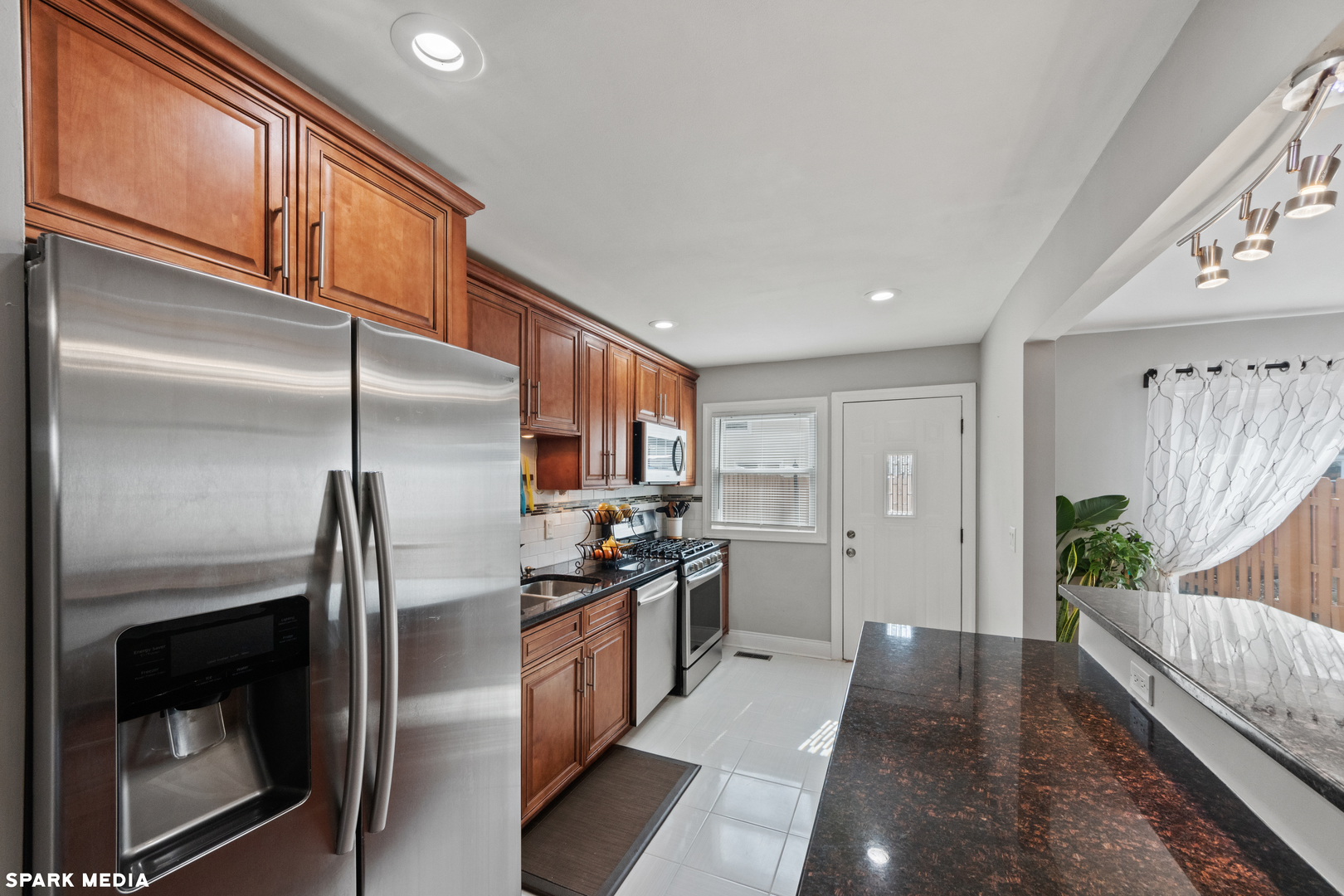 7612 Manchester Manor Hanover Park, IL 60133 - Photo 10 of 30 a kitchen with stainless steel appliances granite countertop a refrigerator a stove and a sink with wooden floor