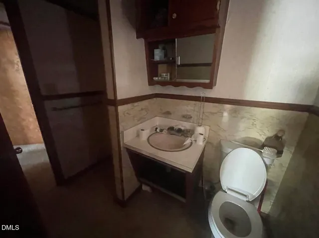 a bathroom with a sink mirror and toilet