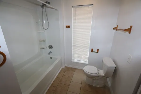 a bathroom with a granite countertop bathtub toilet and sink