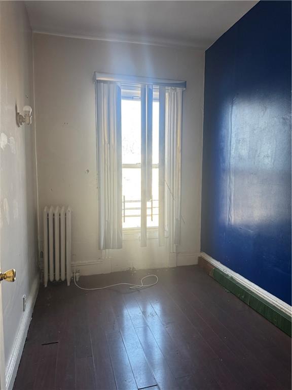 6 Pilling Street Brooklyn, NY 11207 - Photo 16 of 18 an empty room with wooden floor and windows with curtains