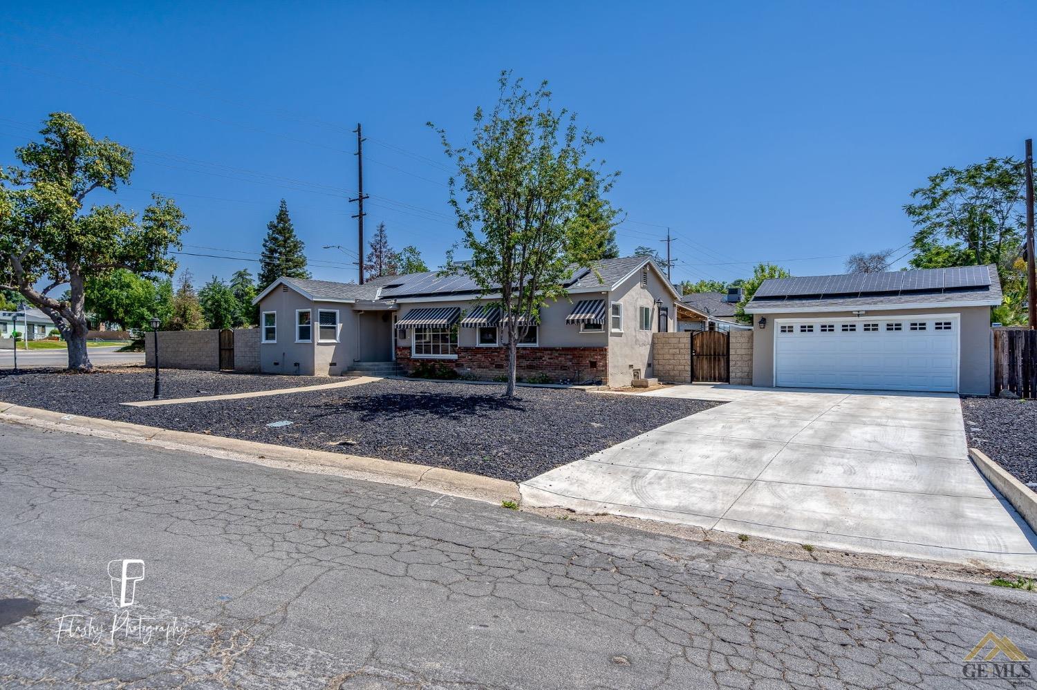 Undisclosed Address Bakersfield, CA 93305 - Photo 2 of 20 a front view of a house with a yard and garage