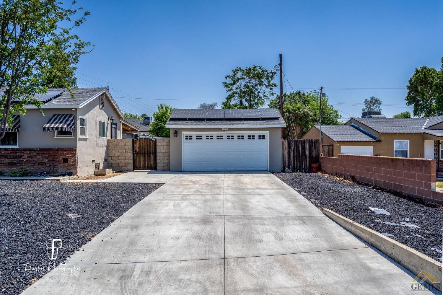 Undisclosed Address Bakersfield, CA 93305 - Photo 4 of 20 a front view of a house with a yard and a garage