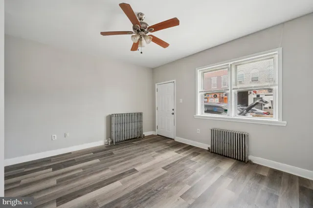 a view of empty room with wooden floor